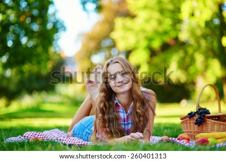 http://thumb101.shutterstock.com/display_pic_with_logo/118180/260401313/stock-photo-girl-having-a-picnic-in-park-lying-on-the-grass-picnic-basket-with-fruits-near-her-260401313.jpg