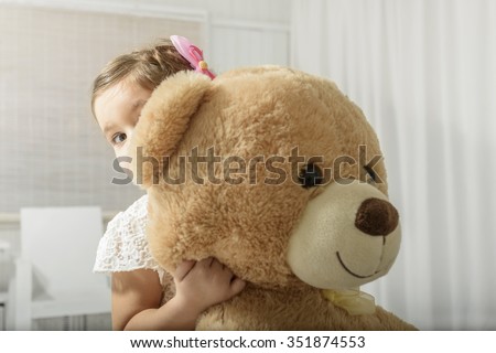 girl hugging huge teddy bear