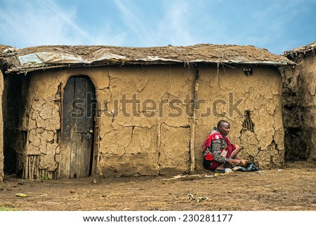 Vlad+Alina118 from Masai tribe working in front of her village house. The Maasai ...