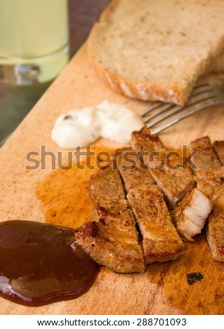 stock-photo-vertical-photo-of-bbq-sauce-with-pork-steak-portion-on-wooden-chopping-board-with-tatar-sauce-one-288701093.jpg