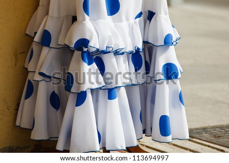 stock-photo-ruffles-and-hemline-of-white-flamenco-dancer-dress-with-blue-pokadots-hanging-outside-a-store-113694997.jpg