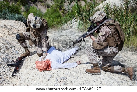 stock-photo-two-us-marines-making-a-search-of-killed-muslim-warrior-176689127.jpg