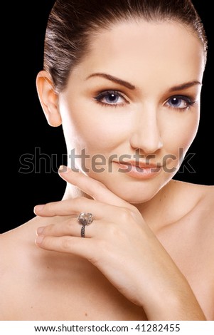 A beauty shot of a pretty young woman wearing a diamond ring in front of a