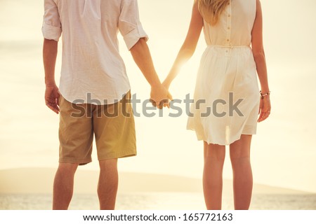 http://thumb101.shutterstock.com/display_pic_with_logo/322021/165772163/stock-photo-young-couple-in-love-attractive-man-and-woman-enjoying-romantic-evening-on-the-beach-holding-165772163.jpg