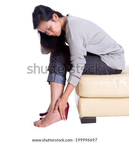 ... female rubbing her hurt heel wearing high heel shoes - stock photo
