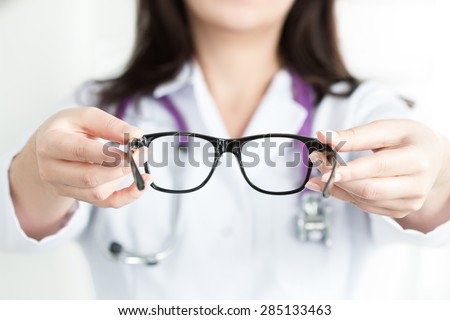 stock-photo-female-oculist-doctor-s-hands-giving-a-pair-of-black-glasses-good-vision-concept-285133463.jpg
