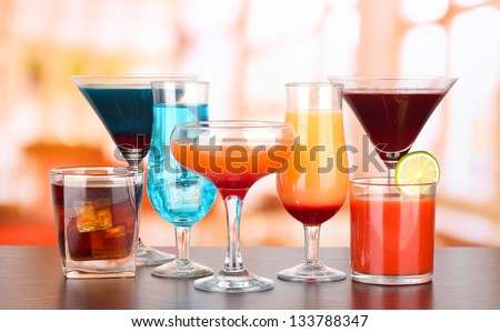 Several glasses of different drinks on bright background - stock photo
