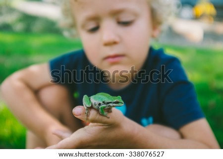 Cute Little Boy Holding a Frog - stock photo