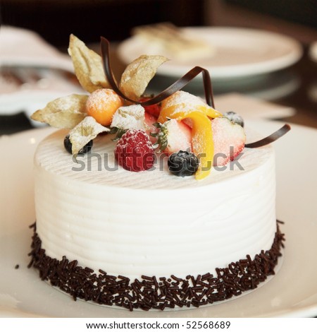White Cream Icing Cake with Fruits and Chocolate - stock photo