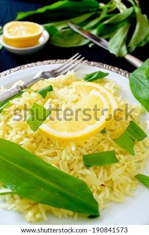 wild leek with saffron basmati rice and lemon om black background - stock photo