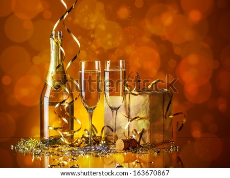 Glasses of champagne with gold ribbon gift - stock photo