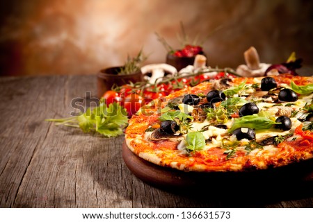 Delicious fresh pizza served on wooden table - stock photo