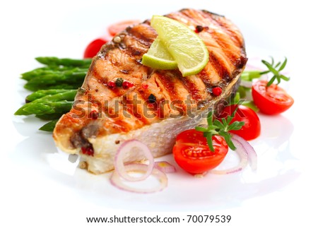 grilled salmon with lime, asparagus and cherry tomatoes on white plate - stock photo